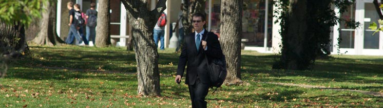 Person in suit walking through campus